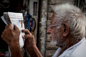 Photo of an older man reading news